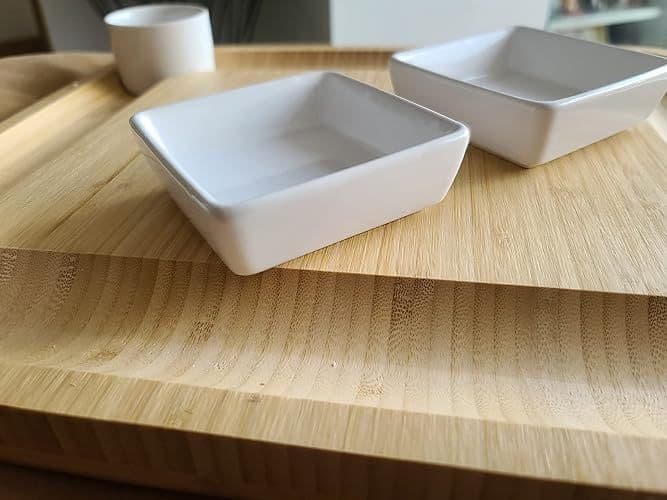 Customer close-up photo of the board's bamboo surface with two small ceramic serving bowls
