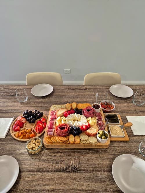 Customer photo of the board fully loaded on a set dining table, with plates laid for guests