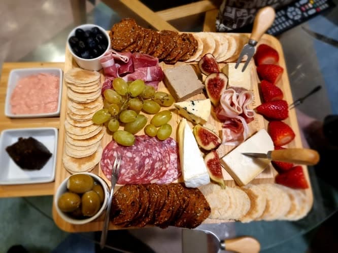 Customer photo of the board arranged with cured meats, cheeses, grapes, strawberries, olives and dips