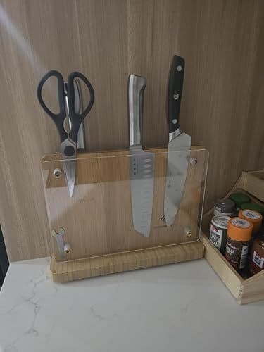 Customer photo of the magnetic knife holder on a kitchen counter holding knives and scissors