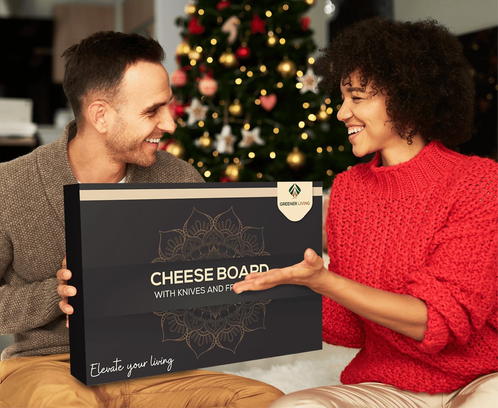 Couple exchanging the cheese board's gift box beside a lit Christmas tree at home