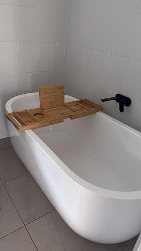 Customer photo of the bamboo bath caddy extended across a freestanding bathtub