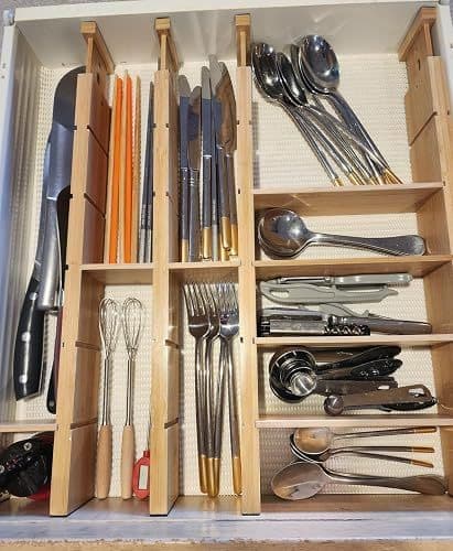 Customer photo of a kitchen drawer organised into compartments holding cutlery and kitchen tools
