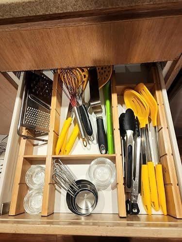 Customer photo of a drawer organised with a grater, whisk, tongs and measuring cups using the dividers