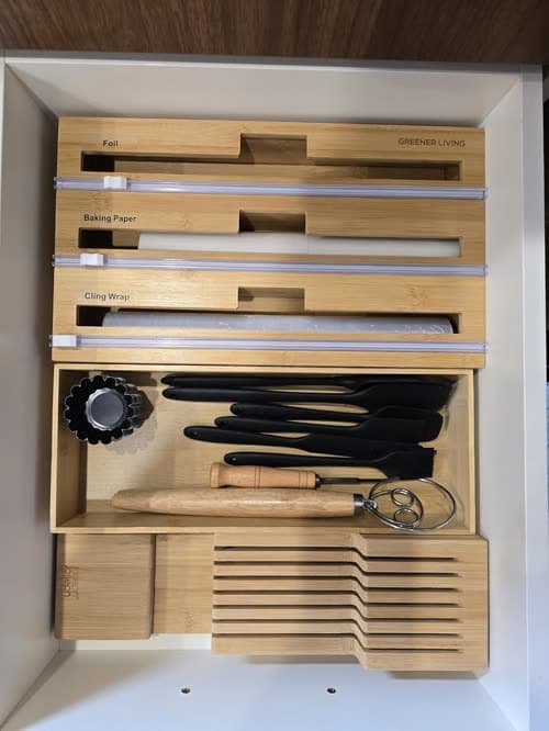 Customer photo of the dispenser fitted inside a kitchen drawer, loaded with three rolls beside a knife block