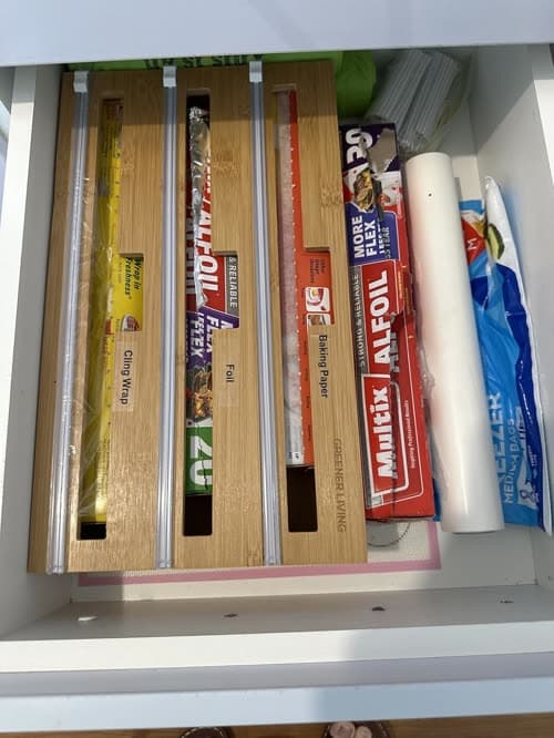 Customer photo of the dispenser in a drawer loaded with supermarket cling wrap, foil and baking paper rolls