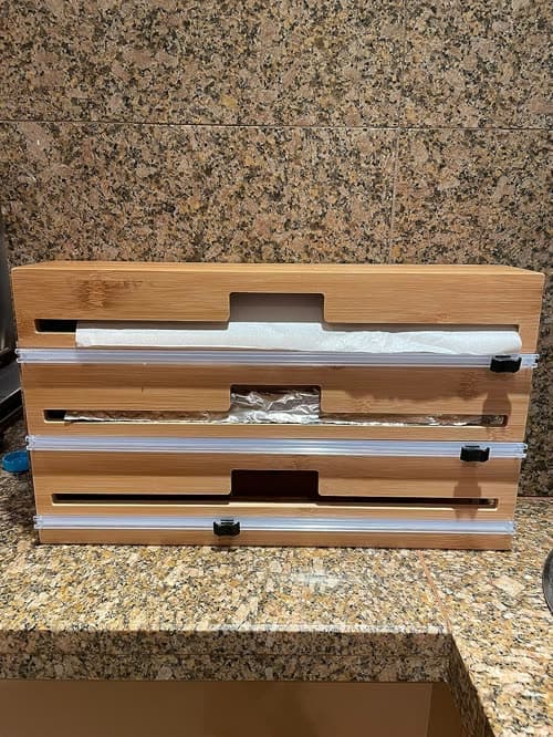 Customer photo of the dispenser on a granite benchtop with foil and cling wrap loaded